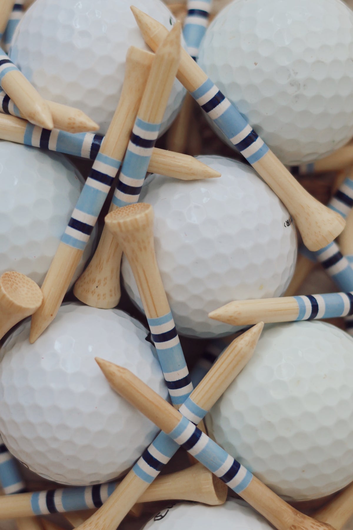 Surfers Paradise 2.75” bamboo golf tees arranged among white golf balls.